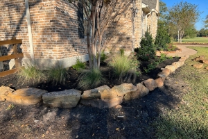 moss rock with pink muhly grass and crape myrtle and mulch