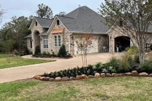 moss rock with pink muhly grass and crape myrtle and mulch