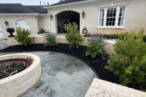 custom firepit landscape installation, black mulch with landscape border, white brick