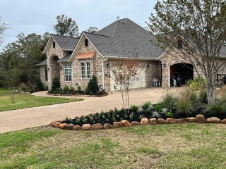 moss rock with pink muhly grass and crape myrtle and mulch